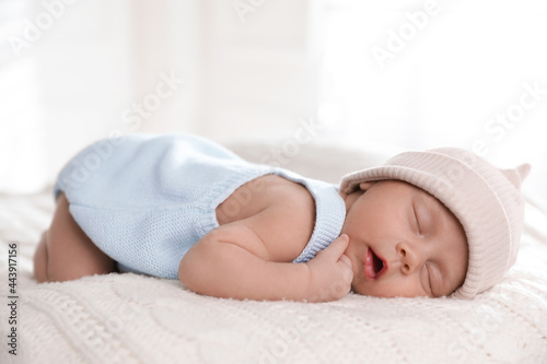 Adorable newborn baby sleeping on white knitted plaid