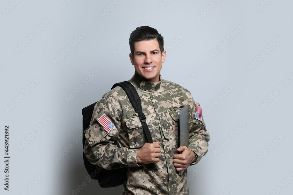 Cadet with backpack and laptop on light grey background. Military education Cadet with backpack and laptop on light grey background. Military education