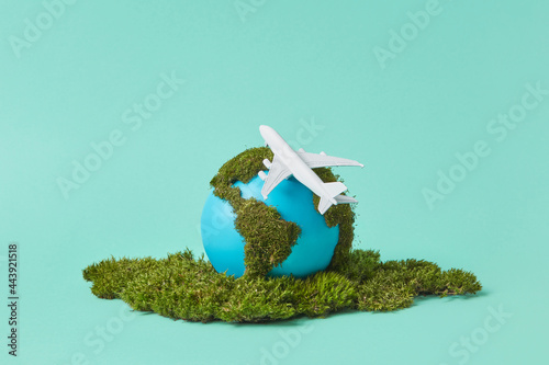 Earth globe with green moss and plane model