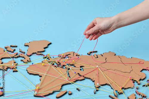 Woman holding thread above map with connections photo