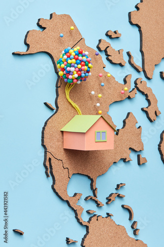Papercraft house miniature with colored balloons on map