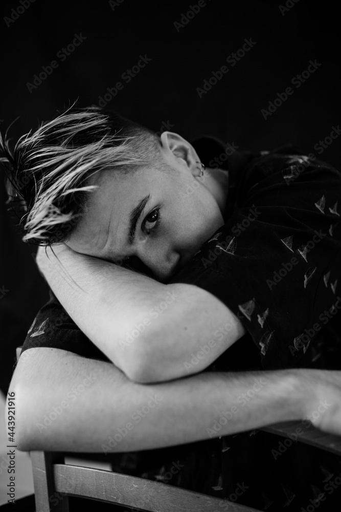 Male portrait black and white looking up face hidden sitting on the chair Male portrait black and white looking up face hidden sitting on the chair