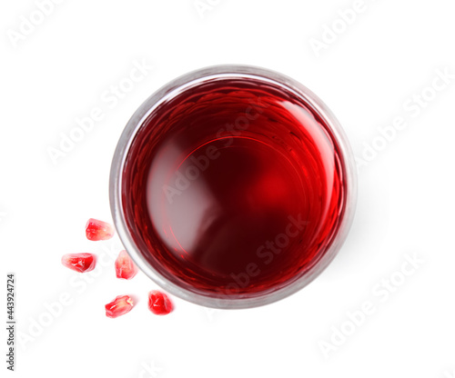 Fresh pomegranate juice in glass and seeds on white background, top view