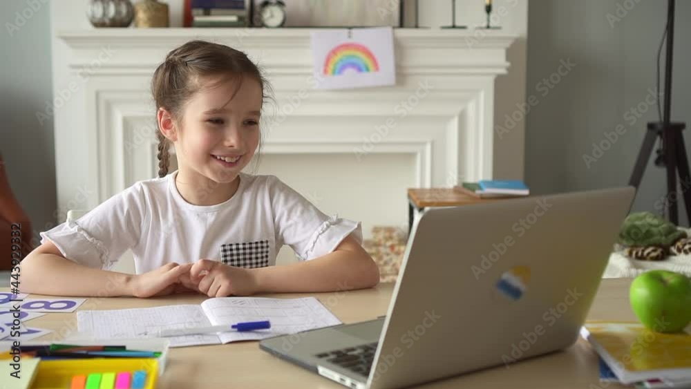 Child smile, talk with online class look at laptop screen Spbd. Girl studying at home, watch video Child smile, talk with online class look at laptop screen Spbd. Girl studying at home, watch video