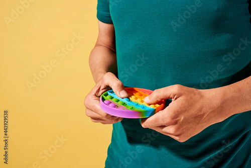 man pops some bubbles of a rainbow destressing toy