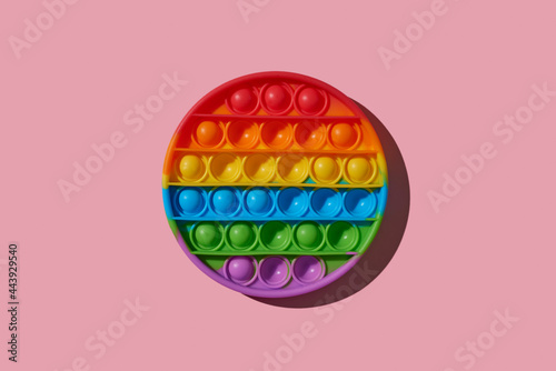 rainbow destressing toy on a pink background