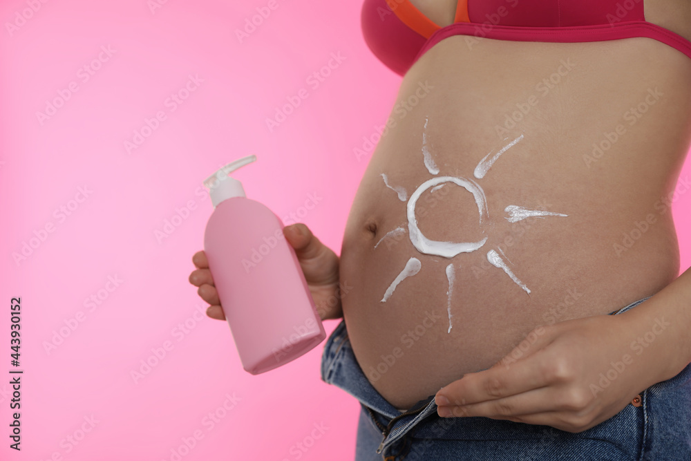 custom made wallpaper toronto digitalYoung pregnant woman with sun protection cream on pink background, closeup. Space for text