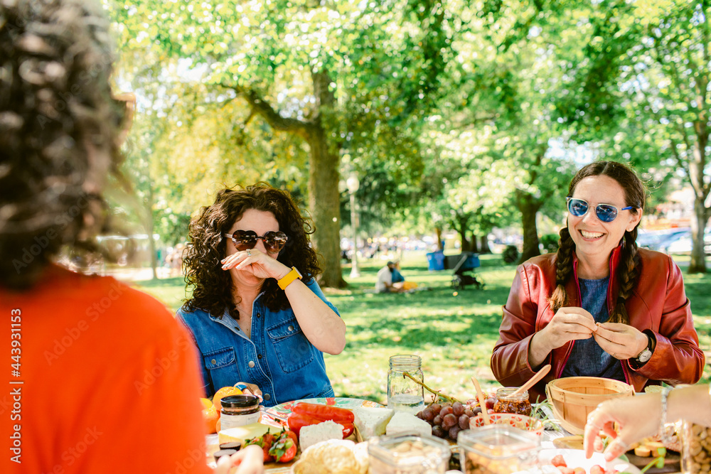© ByLorena/Stocksy - Woman laughing enjoying picnic outdoors © ByLorena/Stocksy - Woman laughing enjoying picnic outdoors