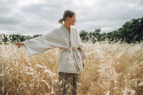 Woman in kimono standing on a windy field photo