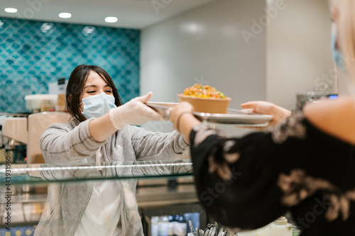 Restaurant employee serving poke bowl for customer photo