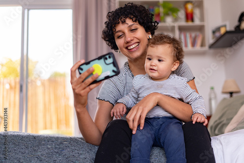 Young mom with her baby in a videocall photo