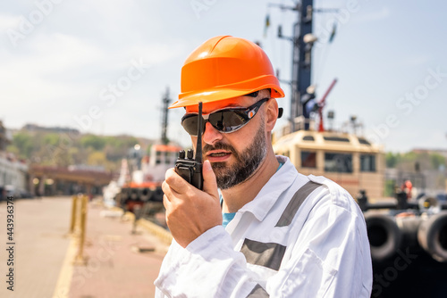 Seaman talking with walkie-talkie radio in port photo