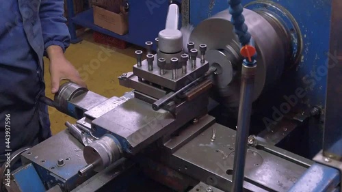 Close up footage of a worker lathing a metallic part.