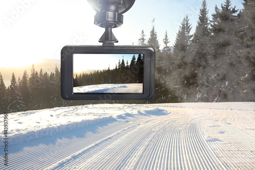 Modern dashboard camera mounted in car, view of road during driving photo