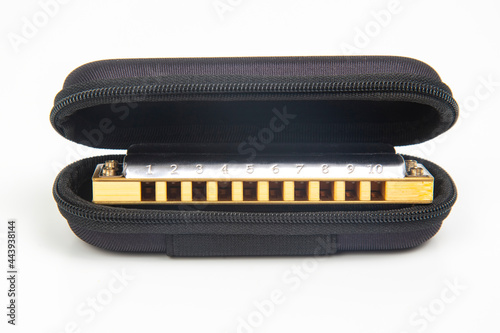 Harmonica in a case on a white background. Classical musical wind instrument.
