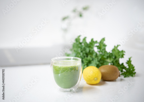 Kale smoothie in a glass on mable countertop