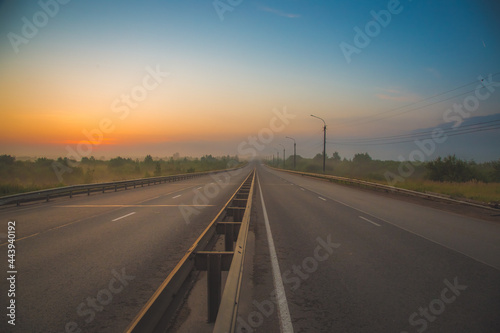 the multi-lane road goes into the distance and gets lost in the predawn haze