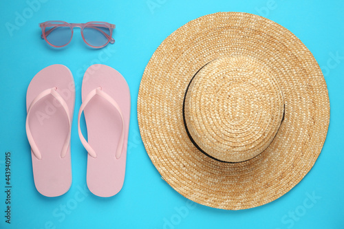 Flat lay composition with straw hat on turquoise background