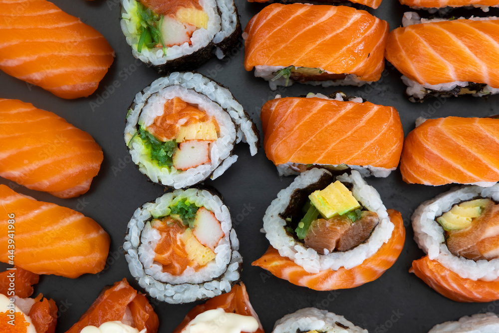 Sake Sushi Nigiri, Maki Rolls with Salmon on a black plate Sake Sushi Nigiri, Maki Rolls with Salmon on a black plate