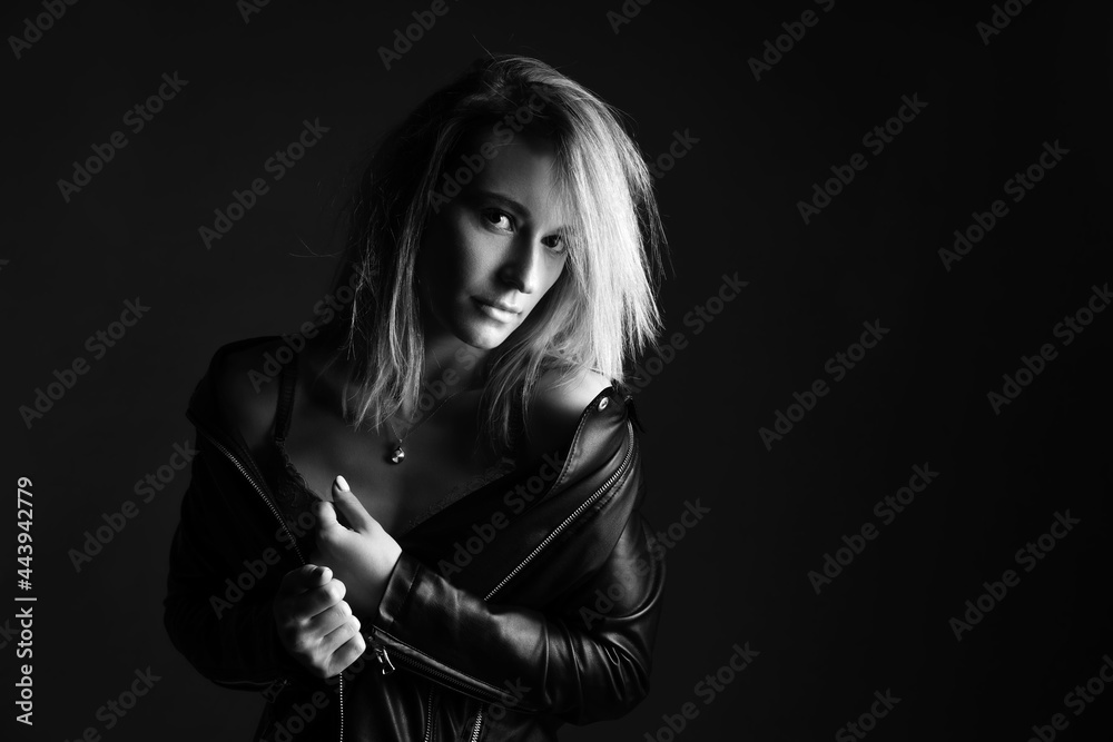 Portrait of a woman in a leather jacket and lingerie, black and white photo. Beautiful caucasian woman of nationality sensitive portrait on black background Portrait of a woman in a leather jacket and lingerie, black and white photo. Beautiful caucasian woman of nationality sensitive portrait on black background