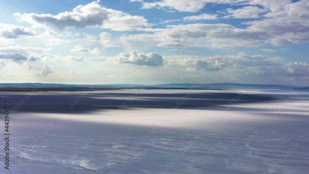 Aerial view of salt lake with beautiful, cloudy, blue sky. Sunlight shining on the ground through the clouds, reflecting some of the sky. 2 Aerial view of salt lake with beautiful, cloudy, blue sky. Sunlight shining on the ground through the clouds, reflecting some of the sky. 2