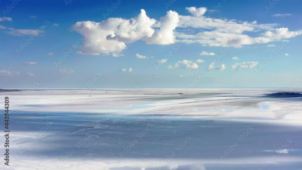Camera panning to the right slowly. Shot of big salt lake. Blue sky with white clouds. Daytime sunlight hitting the ground through the clouds.4K Camera panning to the right slowly. Shot of big salt lake. Blue sky with white clouds. Daytime sunlight hitting the ground through the clouds.4K