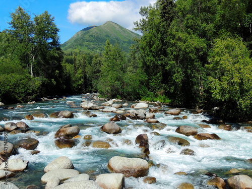 lovely little susitna  river and boulders, with a mountain backdrop, on a sunny  summer day along the way to  hatcher pass  in  alaska photo