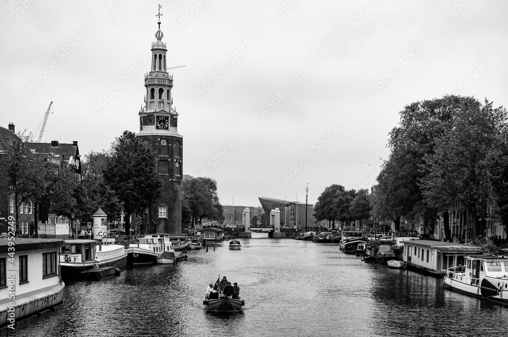 AMSTERDAM, NETHERLANDS. JUNE 06, 2021. Beautiful view of Amsterdam with typical dutch houses, bridges and chanel. Black and white photography