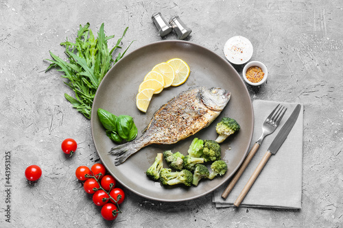 Bild auf Leinwand Plate with fried dorado and vegetables on grunge background