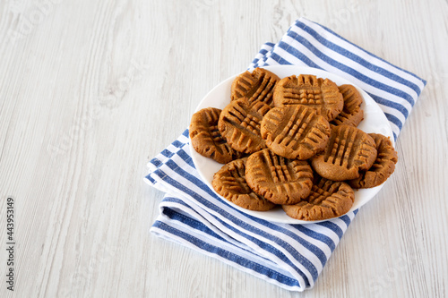 Homemade Peanut Butter Cookies on a plate on a white wooden background, side view. Space for text. photo
