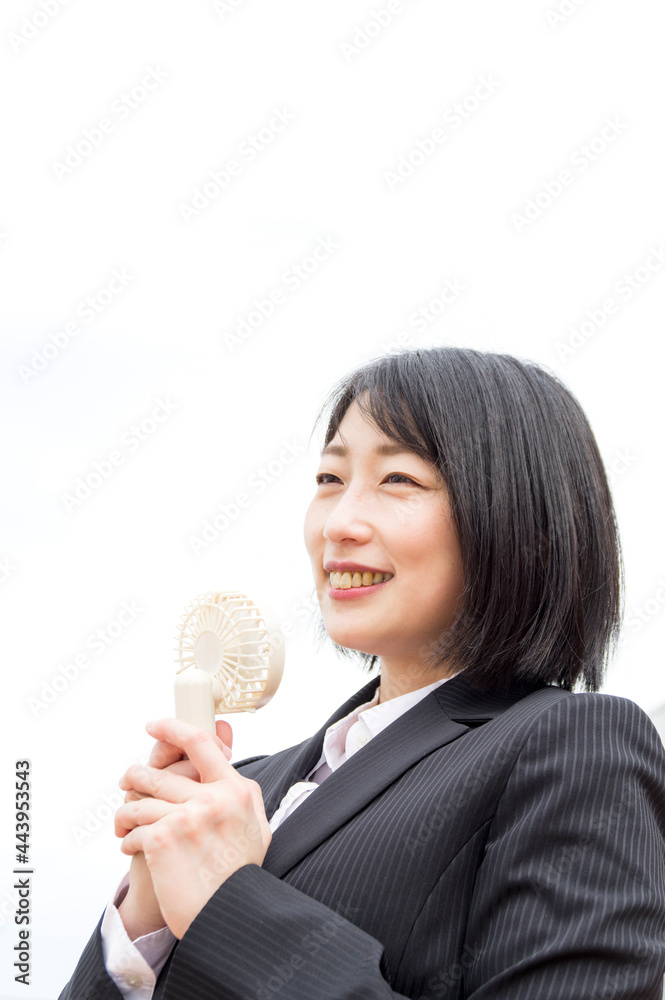 ハンディファンで暑さをしのぐビジネスウーマン