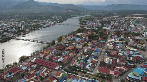 Aerial drone footage above Kampot city, houses and mountains of Bokor in Background, Cambodia photo