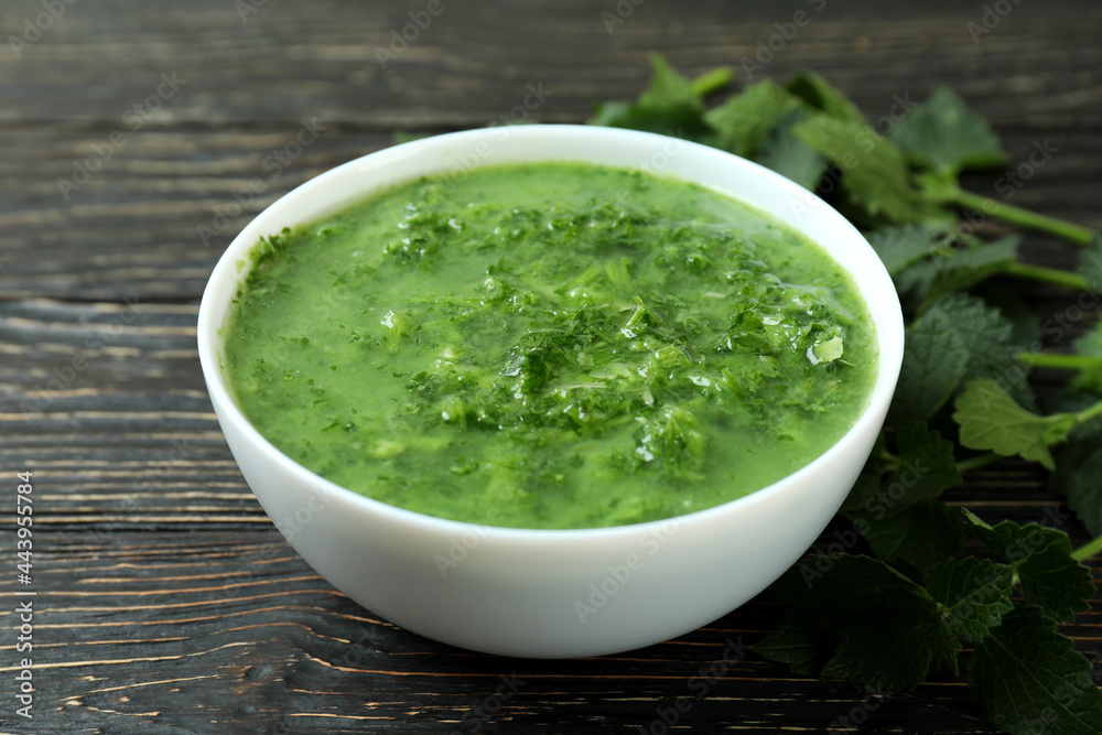 Concept of healthy food with nettle soup on wooden table Concept of healthy food with nettle soup on wooden table