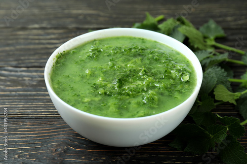 Concept of healthy food with nettle soup on wooden table
