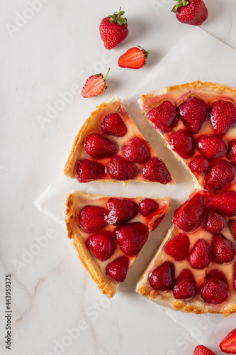 Homemade strawberry custard tart decorated with strawberry on marble background. Top view with place for text