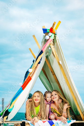 Mother with children playing together in tent. Family camping. Mom with kids Having fun outdoors. Vacation concept. Mothers day, motherhood. © Volodymyr