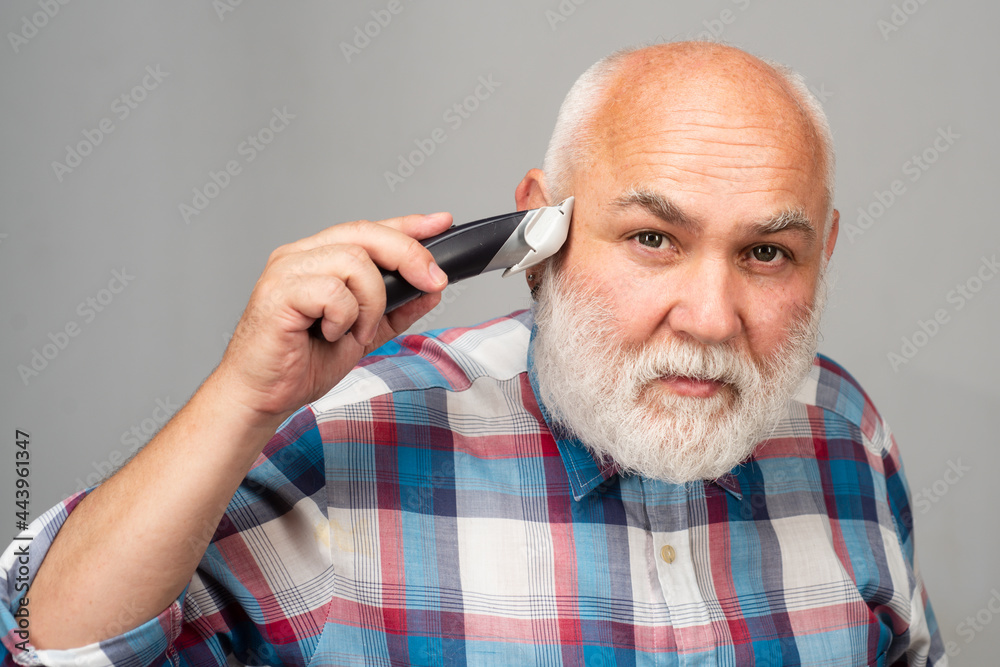 Fototapeta premium Mature man with hair clipper. Old bald man hair clipper, Mature baldness and hair loss concept.