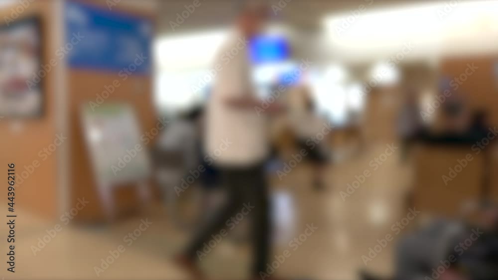 Blurred shot of patients with mask waiting in the crowded lobby at hospital in Japan. 4K July 6, 2021 Blurred shot of patients with mask waiting in the crowded lobby at hospital in Japan. 4K July 6, 2021