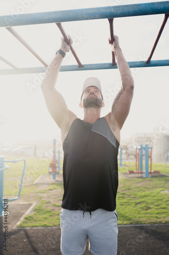 Fitness Model doing pull ups with Sun backlight
