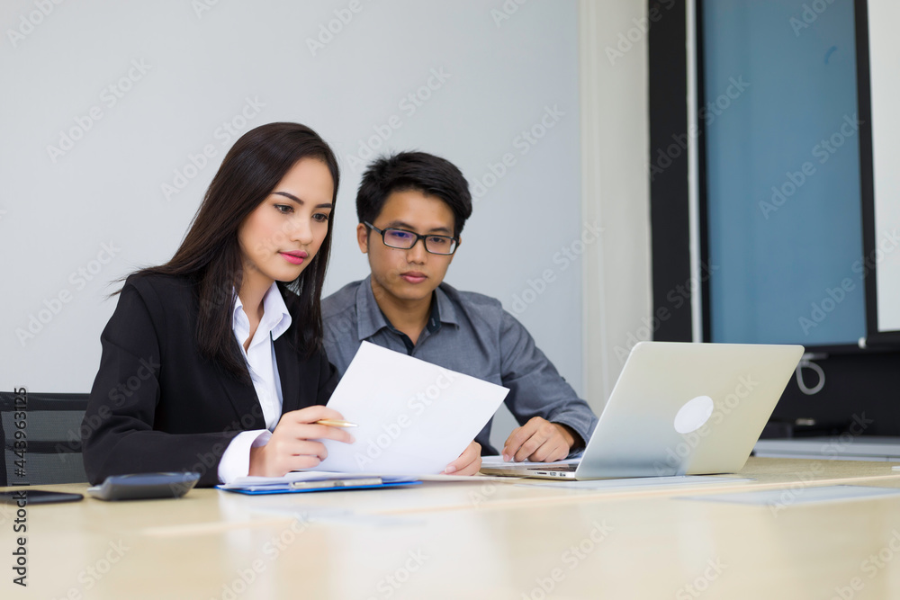 Successful asian business team of two sitting in office and planning work Successful asian business team of two sitting in office and planning work