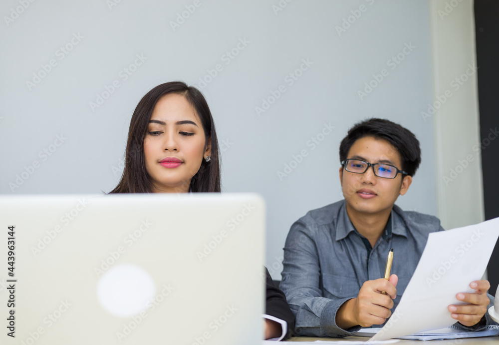 Successful asian business team of two sitting in office and planning work Successful asian business team of two sitting in office and planning work