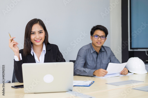 Successful asian business team of two is smiling sitting in office and planning work
