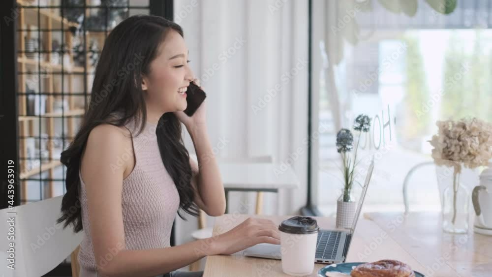 Young Asian woman calling with mobile phone in coffee shop , talking conversation in cafe Young Asian woman calling with mobile phone in coffee shop , talking conversation in cafe