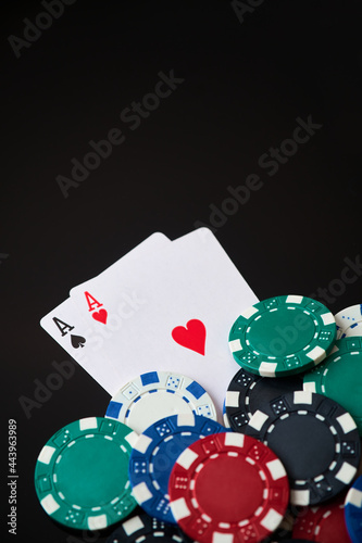 Casino chips and playing cards on dark reflective background