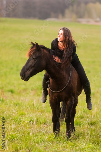beautiful woman with loose hair sitting bareback on a horse © michal