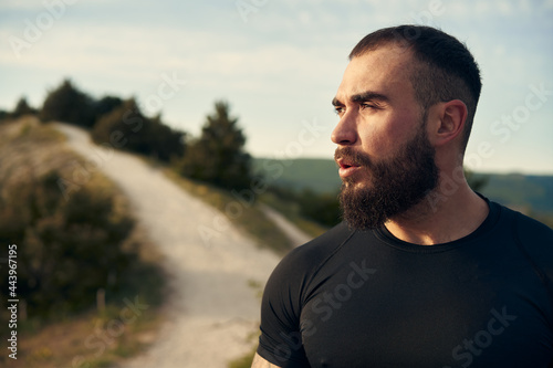 Young bearded man portrait outdoors in the mountains