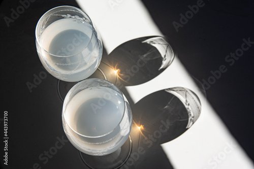 Wine glasses in the sunlight, play of reflections and shadows. Diagonals of black and white.
