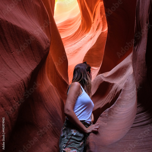 Young woman tourist standing inside Antelope Canyon in Arizona during a visit inside the rift