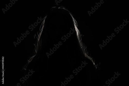 Photography anonymous woman hiding face and identy in the dark shadow