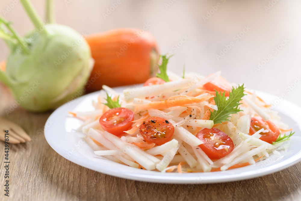 Salad with sliced kohlrabi, carrot, tomato and mizuna leaf on white dish, Vegan food, Healthy eating Salad with sliced kohlrabi, carrot, tomato and mizuna leaf on white dish, Vegan food, Healthy eating